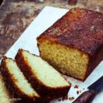 coconut and lime drizzle cake with several slices laying down and knife on the side.