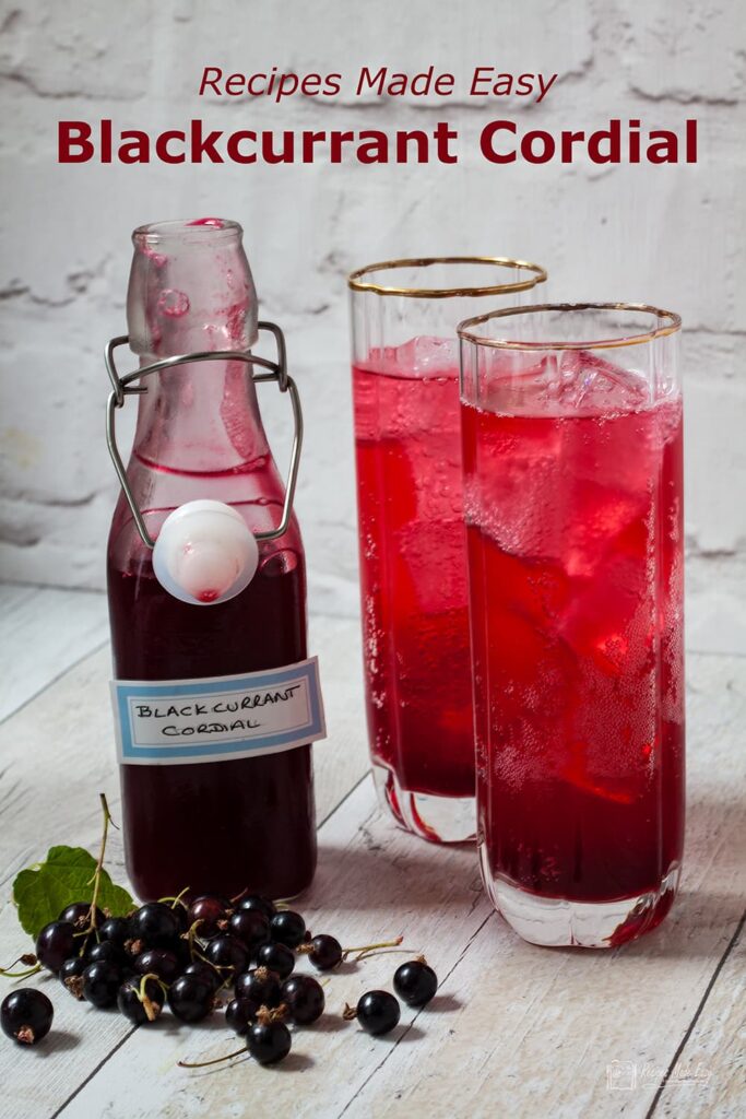 open bottle of blackcurrant cordial and glass of cordial.