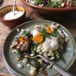 barley and roasted vegetable salad on serving plate with dressing in bowl on the side.