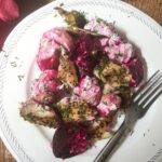 single serving of beetroot, potato and smoked mackeral salad on white plate with fork.