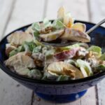 light wardolf salad in blue bowl with spoon