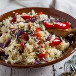 bowl of rice salad with seed spilt onto work surface in front