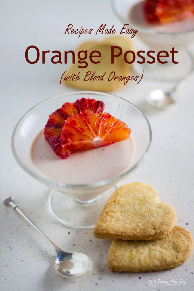blood orange posset in sundae dish with biscuits around.