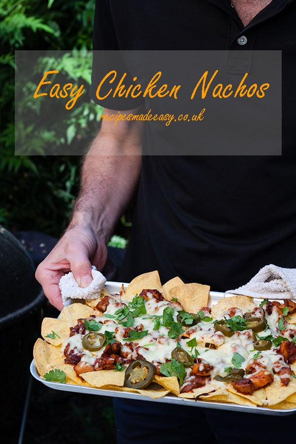 person holding tray of easy chicken nachos.