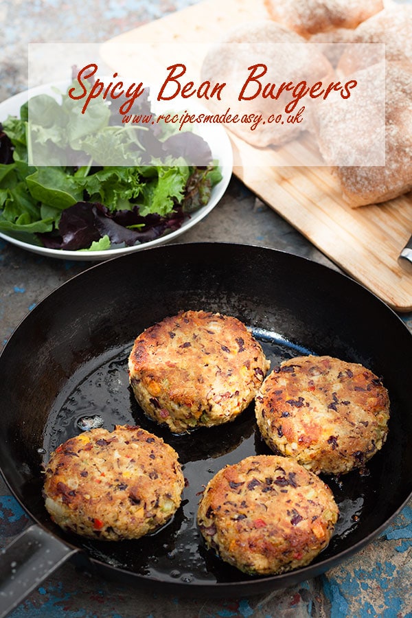 spicy bean burgers in frying pan with text overlayer