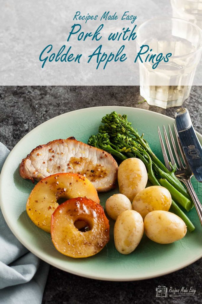 serving of pork with golden apple rings on a plate.