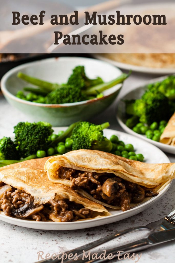 two beef and mushroom pancakes on a plate served with peas, broccoli and beans. with bowl of vegetables behind.
