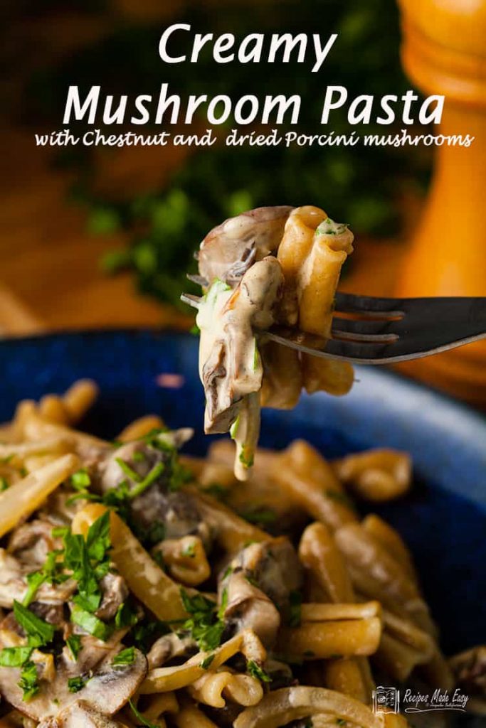 creamy mushroom pasta on blue plate with a fork full lifted from plate.