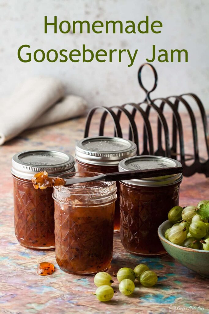 jars of easy gooseberry jam with bowl of gooseberries to the side and toast rack behind.
