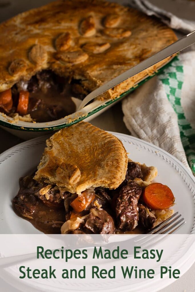 portion of steak and red wine pie on a plate with whole pie behind.