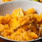 closeup of mashed swede in serving bowl, with spoon.